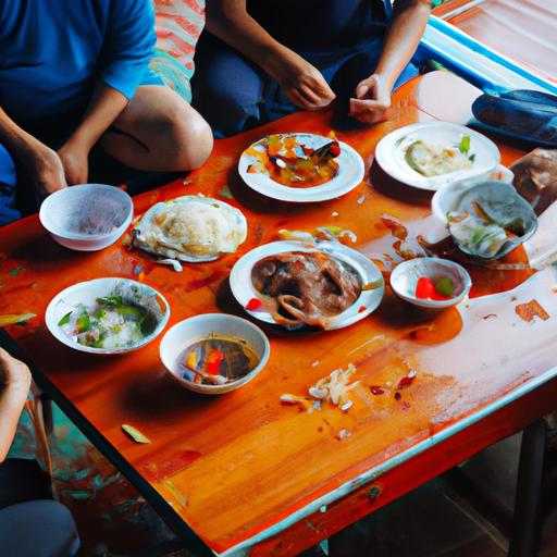 Một nhóm người ngồi quanh bàn thấp trên những chiếc đôn chề để ăn bữa cơm.